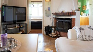 A cozy living room with a fireplace, a television, and a sofa. - 5 Person Holiday Home in Uddevalla (Uddevalla)