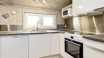 A modern kitchen with white cabinetry, a stainless steel range hood, a built-in microwave, and a dishwasher.