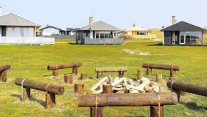 A row of modern cabins with large windows and a grassy field in the foreground. - 6 Person Holiday Home in Lemvig (Lemvig)