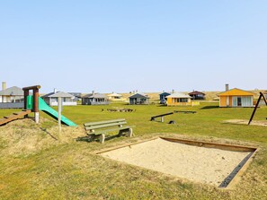 A playground with a slide, benches, and a sandpit. - 6 Person Holiday Home in Lemvig (Lemvig)