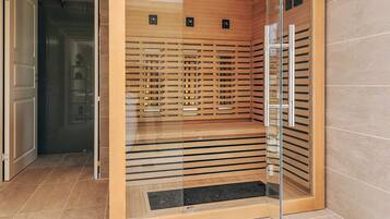 Un ascensor moderno con paneles de madera y puertas de vidrio, que incluye un panel de control con botones y una pantalla digital.