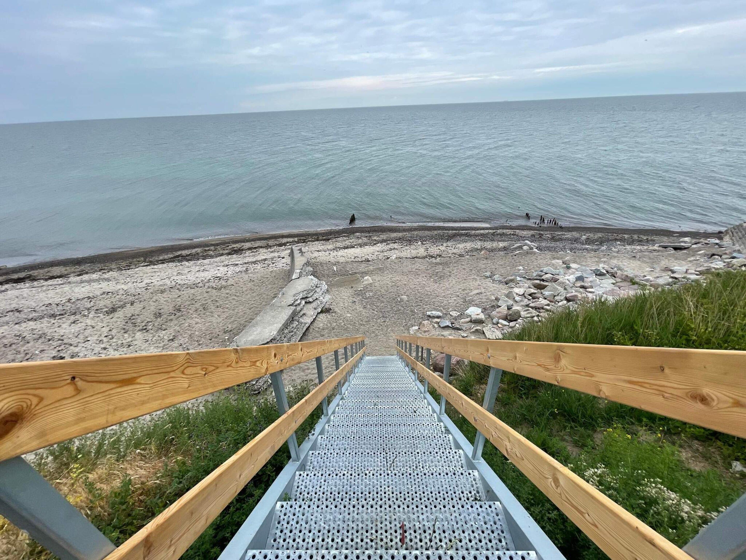 Un escalier menant à une plage avec vue sur la mer.