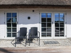 A building with two doors and two chairs in front.