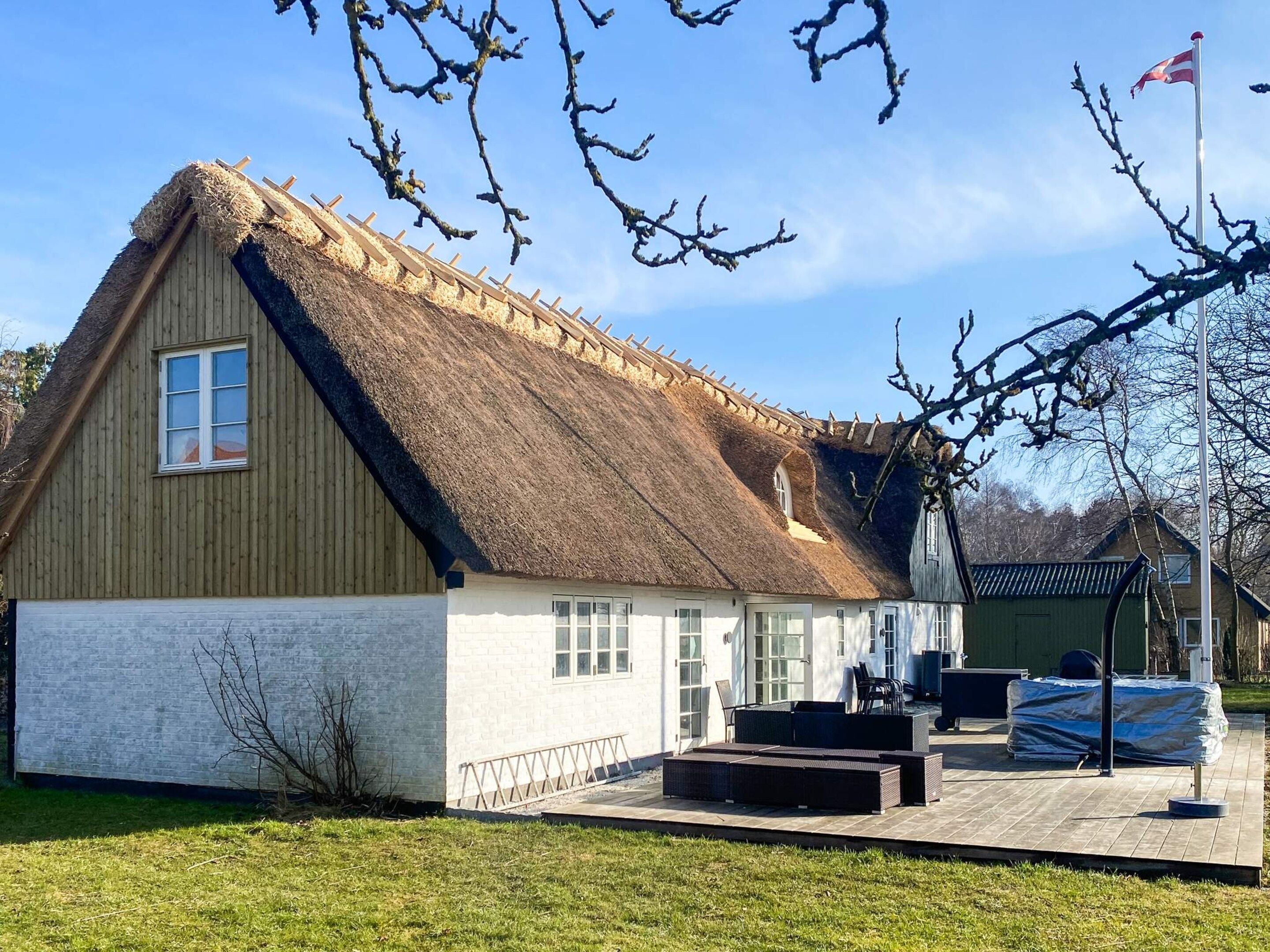 A traditional building with a thatched roof, a wooden exterior, and a small porch area.