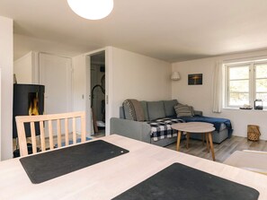 A cozy living room with a sofa, a small round table, and a wooden chair.