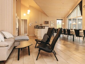 Une pièce spacieuse comprenant un canapé, une table à manger et un coin cuisine.