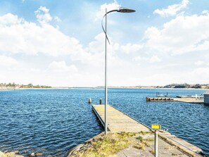 A pier extending into a body of water with a street lamp and a sign. - 5 Star Holiday Home in Hojslev (Hojslev)
