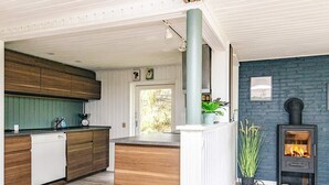 Una cocina moderna con armarios de madera, lavavajillas integrado y una isla central.