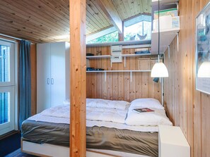 A wooden-paneled room with a bed, a desk, and a window. - Elegant Holiday Home in Nordjylland near Sea (Læsø)