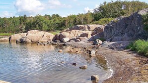 Un paysage naturel caractérisé par une étendue d’eau claire, entourée de rochers et de végétation.