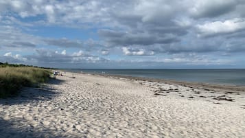 Una playa arenosa con cielo despejado y horizonte lejano.