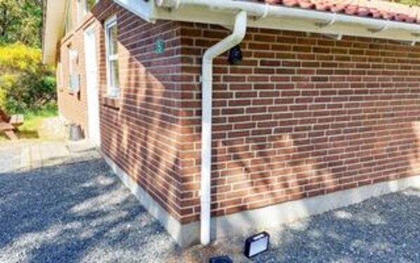 A brick building with a white gutter running along the roof edge. - 8 Person Holiday Home in Blavand (Blavand)