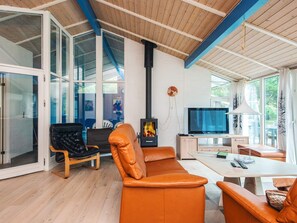 Un salon moderne avec une cheminée, un téléviseur et un canapé.