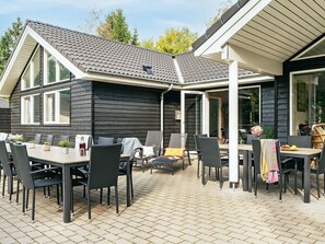 Enjoy dining and socializing in this outdoor patio area, featuring tables and chairs amidst a, enclosed space.