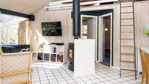 Una sala de estar moderna con chimenea, televisión y sofá.