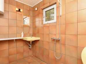 A small bathroom with a sink, mirror, and shower. - Lovely Holiday Home in Jutland near Sea (Vestervig)
