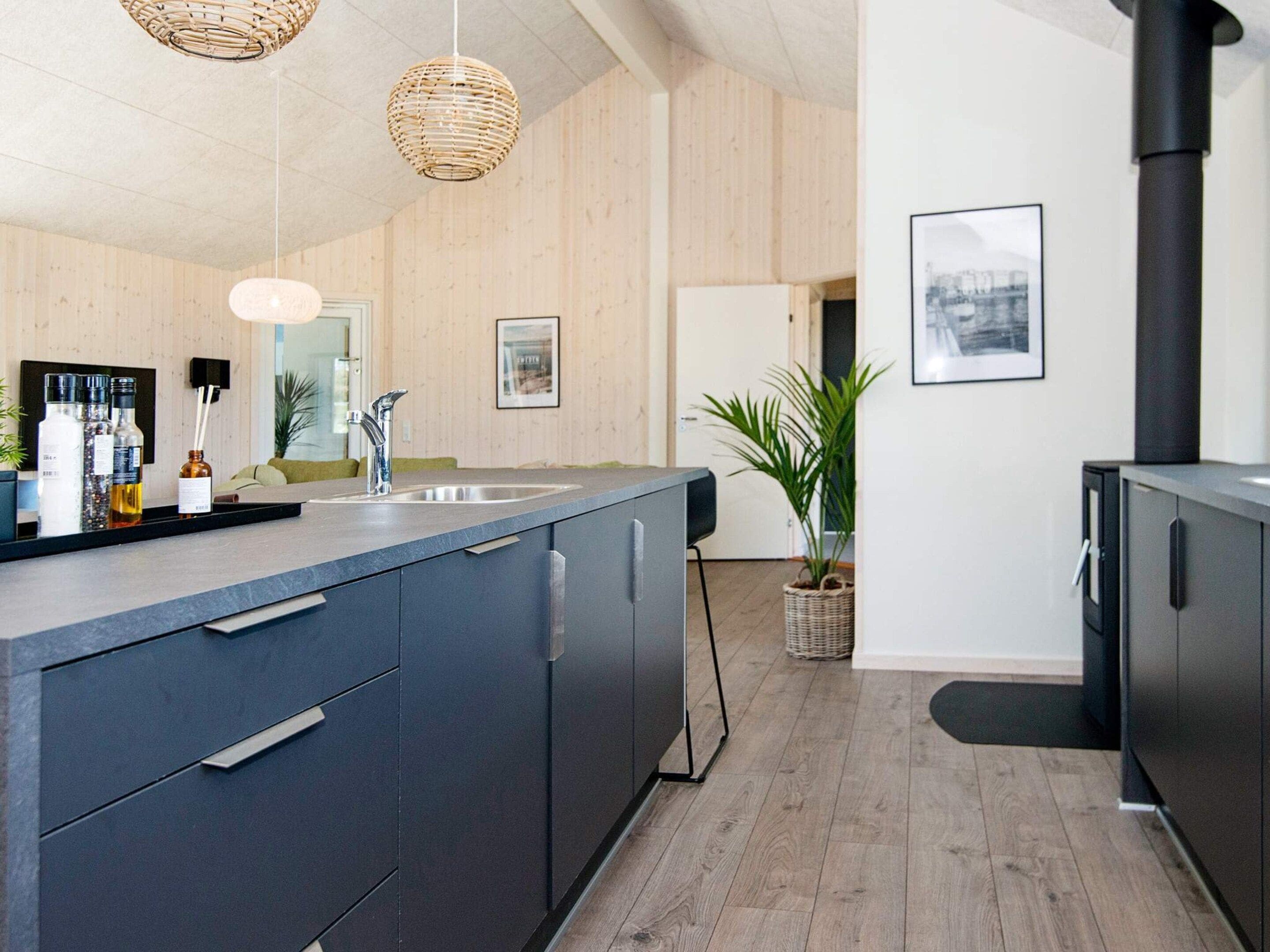 Una cocina moderna con una isla central, electrodomésticos de acero inoxidable y una estufa negra.