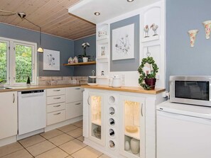 Enjoy a kitchen with white cabinetry, a wooden countertop, and a wine cooler.