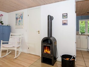 Cozy space with a wood-burning stove, comfortable seating area, and artwork on the walls.