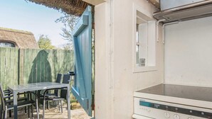 A kitchen with a built-in oven and a table with chairs outside. - Traditional Holiday Home in Jutland near Sea (Fano)