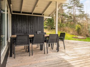 An outdoor dining area with a wooden table and chairs, a grill, and a view of the surrounding forest. - 8 Person Holiday Home in Ebeltoft (Ebeltoft)