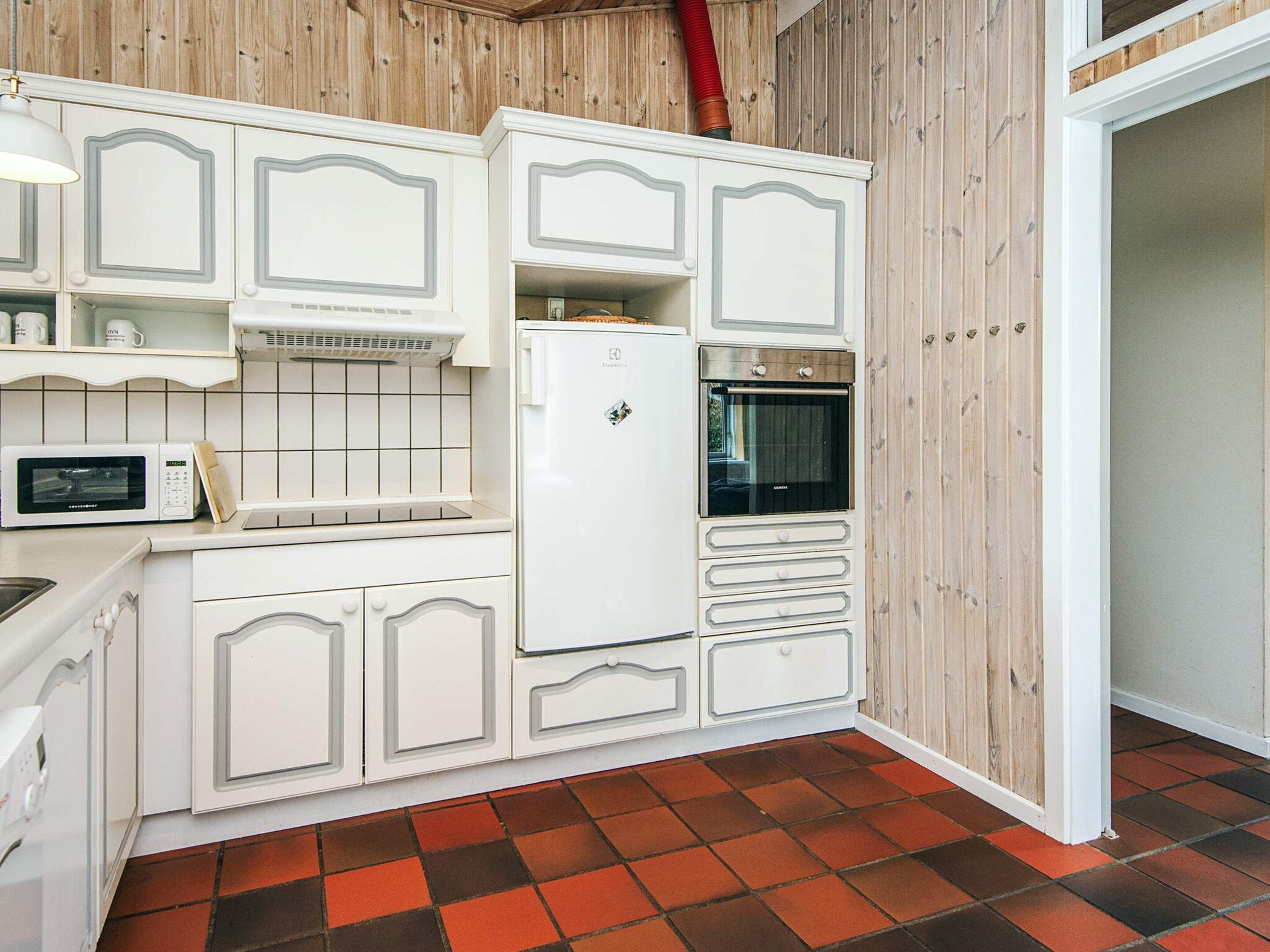 A compact kitchen with white cabinetry, a microwave, a refrigerator, and an oven.