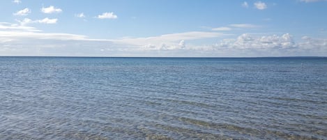 On aperçoit clairement une mer calme, avec une côte lointaine à l’horizon.