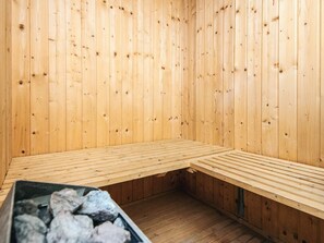 Un cuarto de sauna con paredes y bancos de madera.