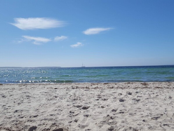 A beach with sand and water, a clear sky, and a distant ship. - 8 Person Holiday Home in Ebeltoft (Ebeltoft)