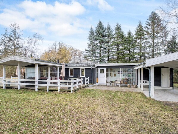 A two-story house with a covered porch and a fenced yard.