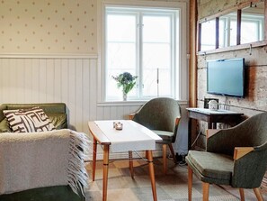 A cozy room with a sofa, two chairs, a table, a window with a view, and a television mounted on the wall. - 10 Person Holiday Home in Farjestaden (Farjestaden)
