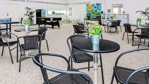 A spacious indoor area with multiple tables and chairs, a pool table, and potted plants. - 6 Person Holiday Home in Brovst (Brovst)