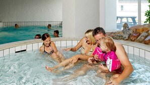 An indoor swimming pool with tiled walls and a clear view of the outside. - 6 Person Holiday Home in Brovst (Brovst)