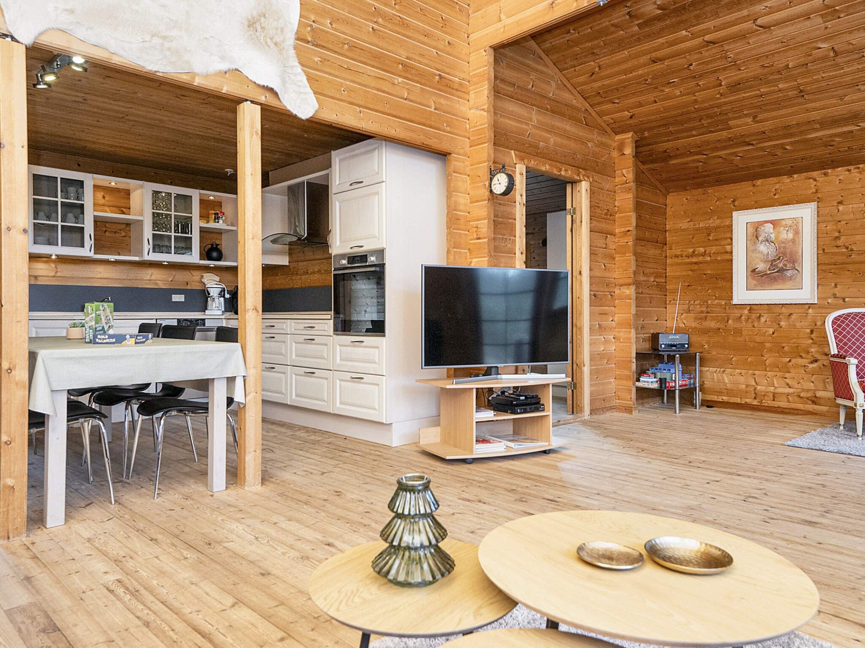 L’intérieur d’une cabane en bois comprend un coin repas, une cuisine et un espace de vie.