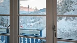 A window with a view of a snowy landscape, including a staircase and a railing.