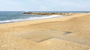 A sandy beach with a rocky breakwater and calm sea. - Serene Holiday Home in Vestervig With Terrace (Vestervig)