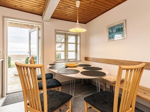 A dining area with a round table, six chairs, and a hanging light fixture. - 8 Person Holiday Home in Svendborg (Svendborg)