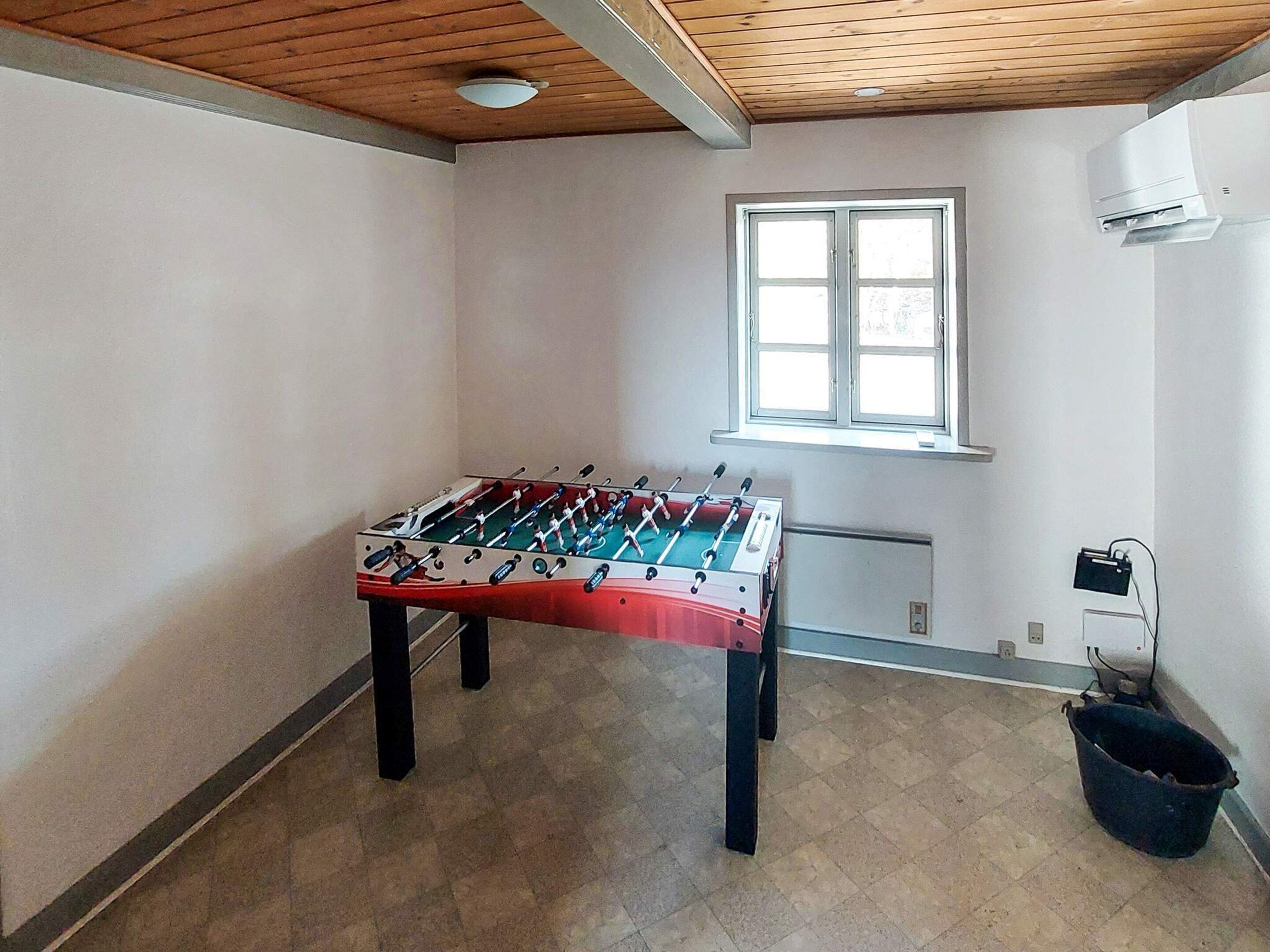 Et værelse med et bordtennisbord, et vindue og en aircondition.
