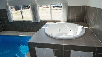 A bathroom with a bathtub, a window, and a view of the outside.