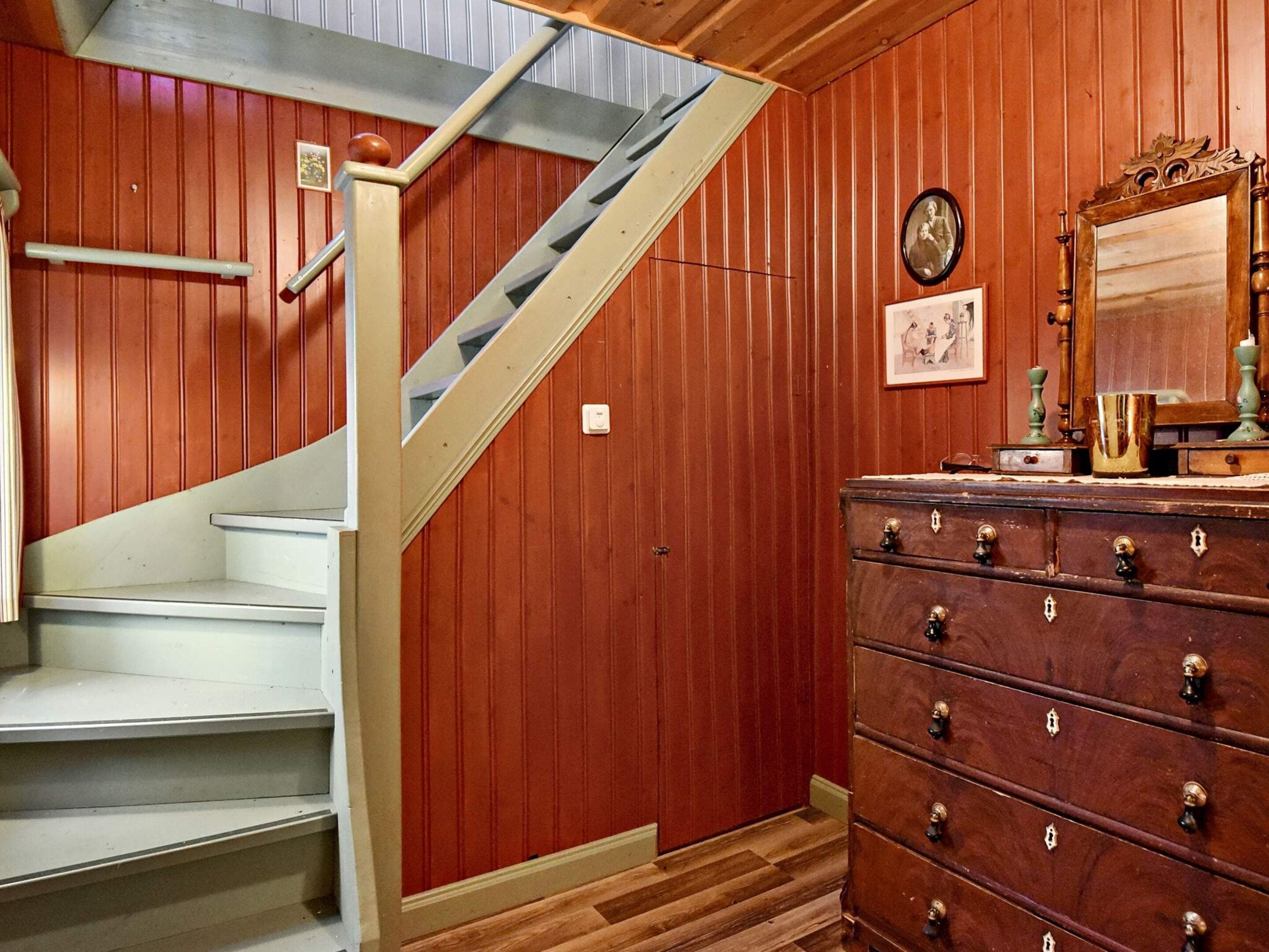 A staircase with a wooden handrail and a white wall.