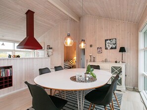 A modern dining area with a round table, black chairs, and pendant lighting. - 4 Star Holiday Home in Svendborg (Svendborg)