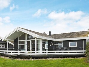 A modern house with a covered porch, large windows, and a tiled roof. - 4 Star Holiday Home in Svendborg (Svendborg)