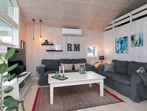 A modern living room with a grey sofa set, a white coffee table, and a patterned rug. - 4 Star Holiday Home in Svendborg (Svendborg)