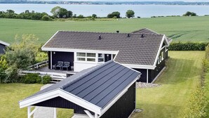 Een huis met een garage, een gazon en uitzicht op een waterlichaam.