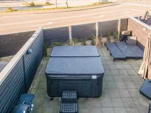 A rooftop patio with a large black storage unit, a small table, and a bench. - Holiday Home in BlÃ¥vand (Blavand)