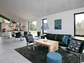 A modern living space with a dining area, a sofa, and a coffee table.