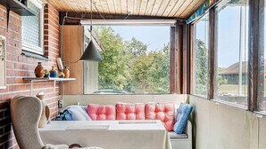 Un rincón acogedor con un banco acolchado, una mesa y una silla.