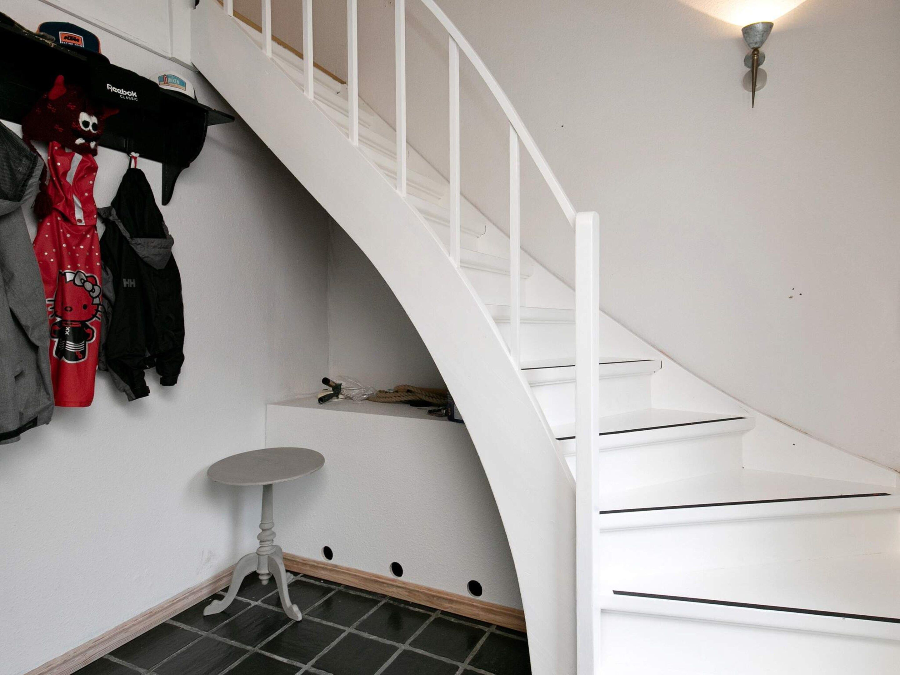 A staircase with white railings and a small table at the bottom.