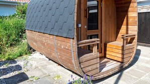 A wooden cabin with a curved roof, a small porch, and a door. - Holiday Home in LÃ¸kken (Lokken)