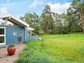 A blue house with a paved entrance, a small garden, and a grassy yard. - Holiday Home in NykÃ¸bing Sj (Nykobing Sjaelland)